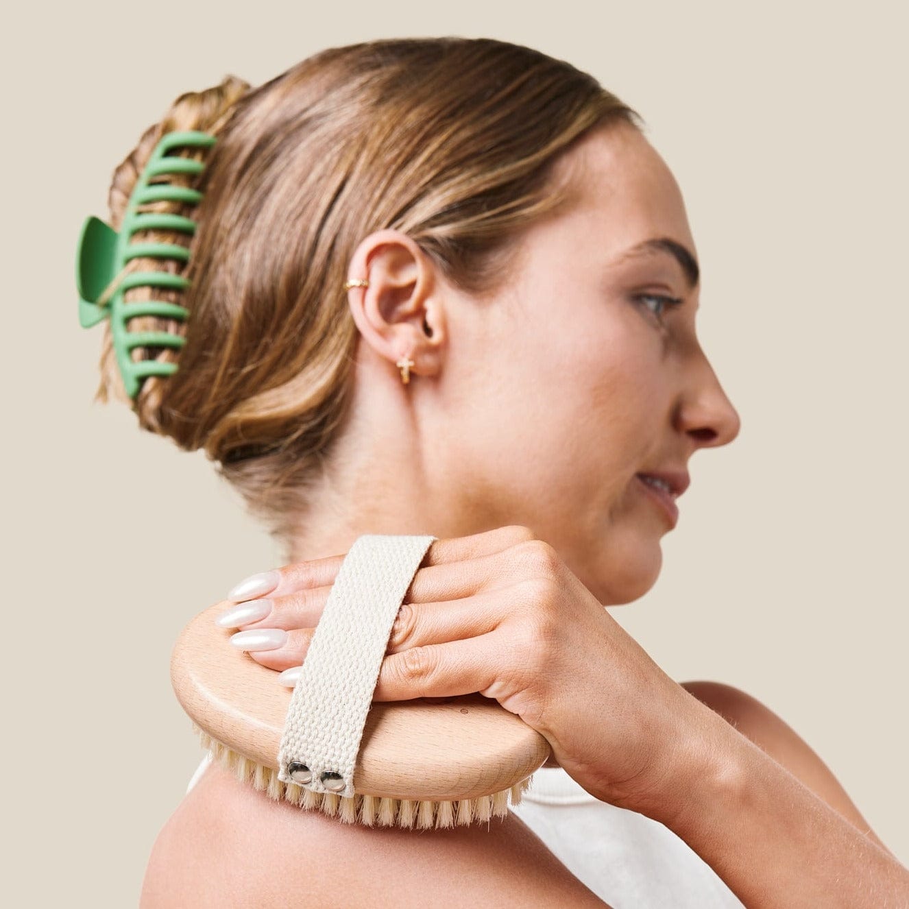 Model using dry bush on shoulder with green hair clip in hair