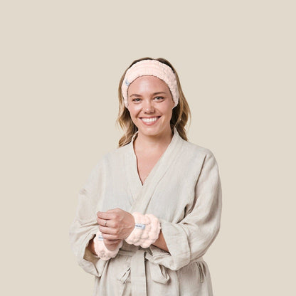 Model wearing light pink wash cuffs and spa headband looking front on to camera