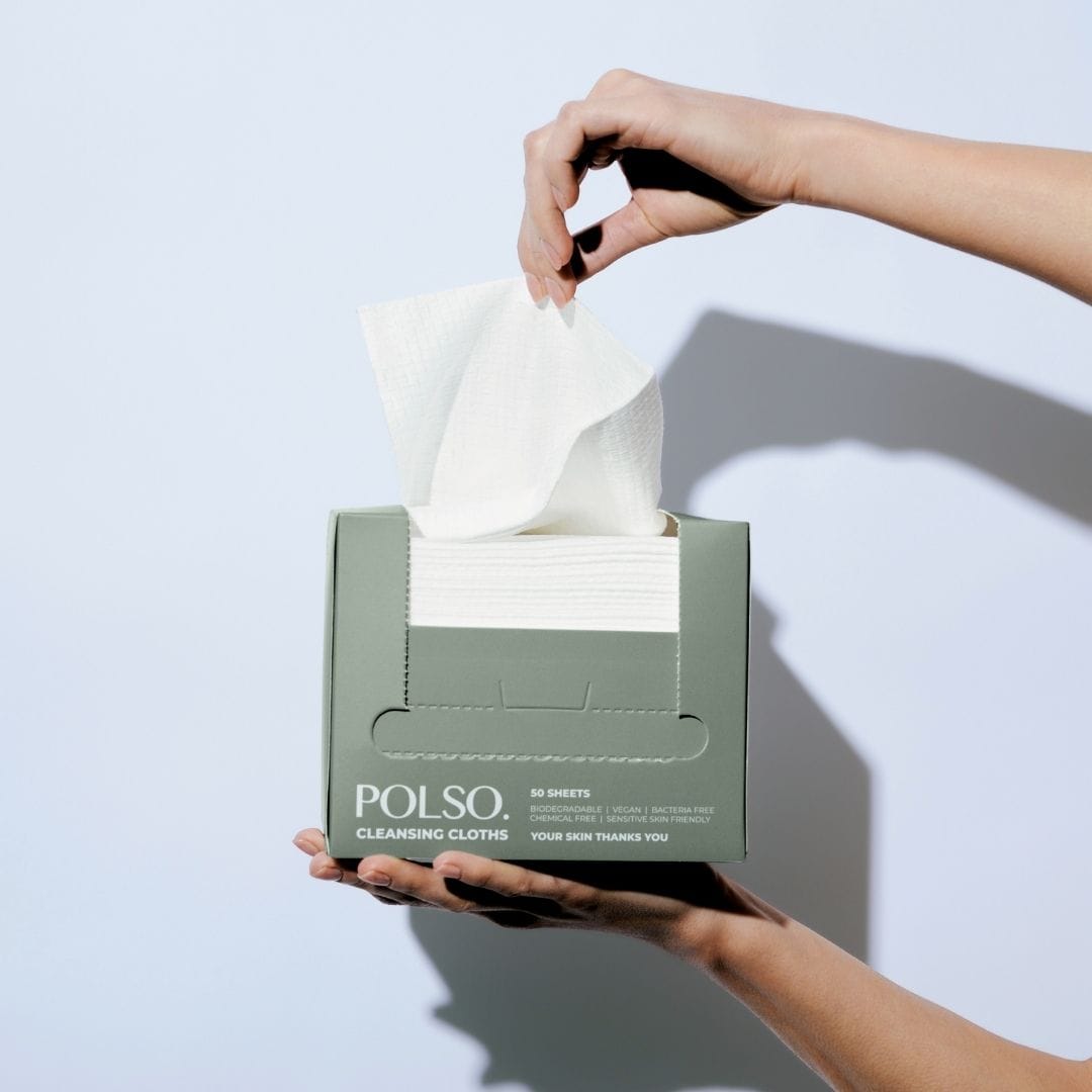 Person opening a box of POLSO cleansing cloths against a light background